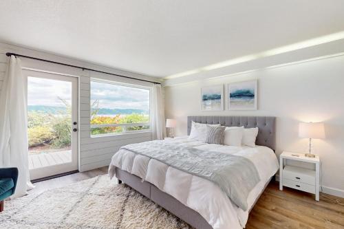 a bedroom with a large bed and a large window at Belfair Bliss in Belfair