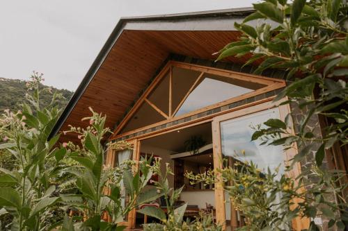 a house with a large window on the side of it at Casa Awänímä - Luxury Permaculture Hotel & Eco-Retreat in Tzununá