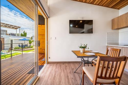 a kitchen and dining room with a table and a balcony at Macondo Ecolodge Guaria Morada - Estrella de Fuego in Coco