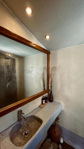 a bathroom with a sink and a large mirror at Δυό Πηγές in Mouresi