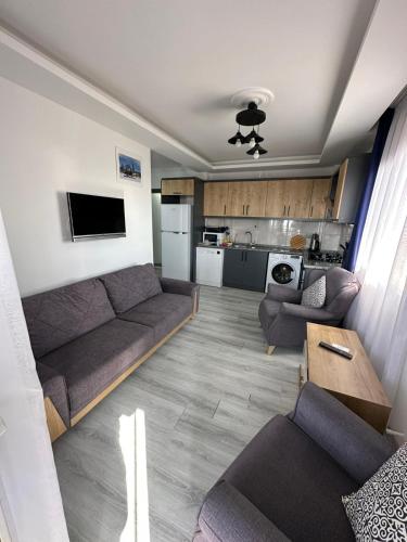 a living room with a couch and a kitchen at Mavi Restaurant & Apartments 3 in Didim