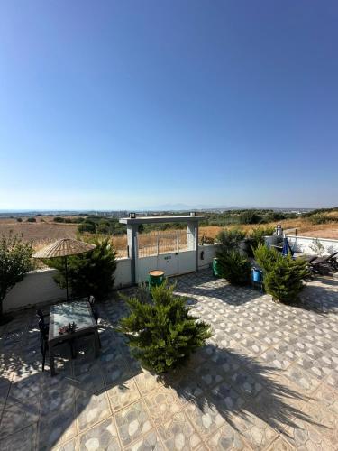 a patio with a table and some bushes at Mavi Restaurant & Apartments 3 in Didim