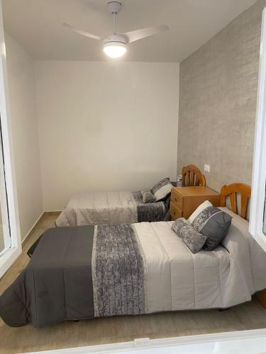 a bedroom with two beds and a ceiling fan at Casa San Pedro in San Pedro del Pinatar