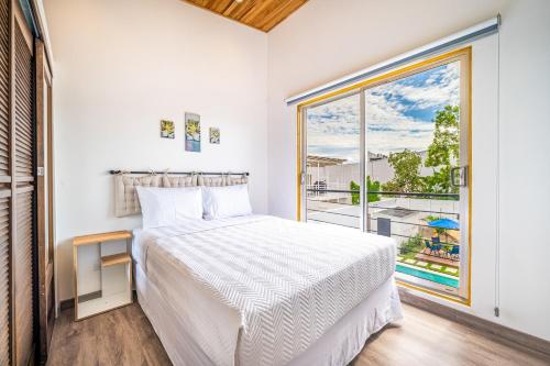 a bedroom with a bed and a large window at Macondo Ecolodge Alpinias - Veranera in Coco