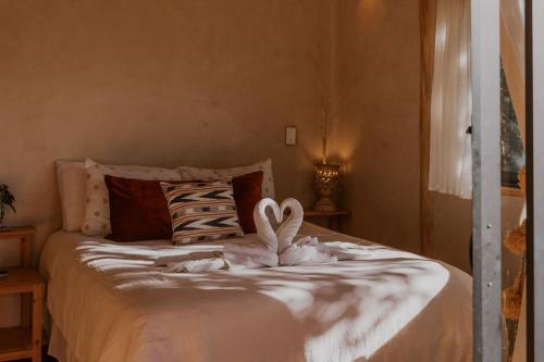 a bedroom with a bed with two towels on it at Casa Awänímä - Luxury Permaculture Hotel & Eco-Retreat in Tzununá