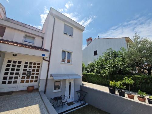 een wit huis met een patio en een hek bij Apartments Luigi in Umag