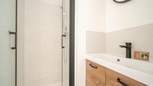 a bathroom with a sink and a shower at Albatros in Saint-Nazaire