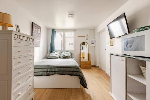 a small bedroom with a bed and a dresser at Les Studios Parfaitement Imparfaits - Lens Louvre-Bollaert in Lens