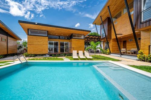 a swimming pool in front of a house at Macondo Ecolodge Heliconia - Bromelia in Coco