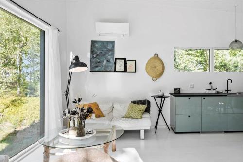 a living room with a white couch and a glass table at 2029-Stege-Telefonstien-41 in Stege