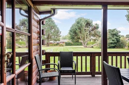 a porch with chairs and a view of a golf course at R962-Rodvig-Skovstumperne-12 in Rødvig