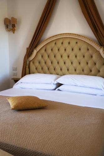 a bed with a headboard and a pillow on it at DONNA LUCREZIA b&b Boutique Hotel Style - relax & business stay in Bisceglie