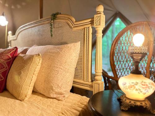 a bedroom with a bed and a table with a lamp at Beloved Cabin - Bell Tent 1 - Romance Bell in Eatonton