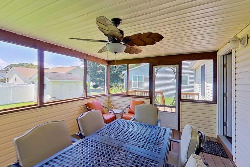 a screened in porch with a table and a ceiling fan at Ocean Way Estates --- 32676 E Riga Dr in Ocean View