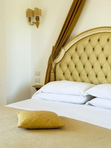 a bedroom with a large bed with a gold headboard at DONNA LUCREZIA b&b Boutique Hotel Style - relax & business stay in Bisceglie