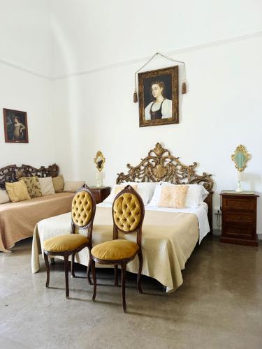 a bedroom with a large bed and two chairs at DONNA LUCREZIA b&b Boutique Hotel Style - relax & business stay in Bisceglie