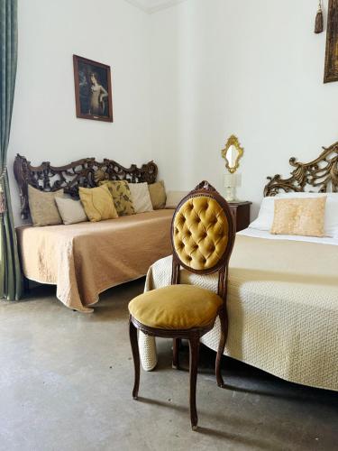 a room with two beds with a chair and a bed at DONNA LUCREZIA b&b Boutique Hotel Style - relax & business stay in Bisceglie