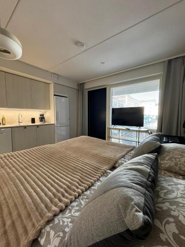 ein Schlafzimmer mit einem großen Bett mit einem großen Fenster in der Unterkunft Pramea Apartments Aallonharja 6 in Jyväskylä