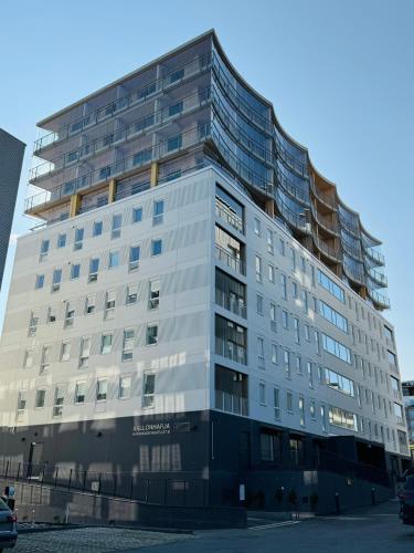 ein hohes weißes Gebäude mit vielen Fenstern in der Unterkunft Pramea Apartments Aallonharja 6 in Jyväskylä