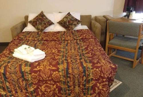 a bed in a hotel room with towels on it at Guardian Inn in Le Center