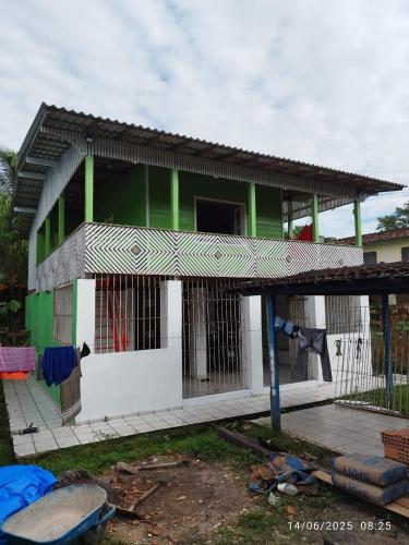 a green and white house with a building at Casa de descanso e lazer in Belém