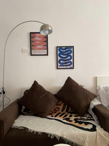 ein Wohnzimmer mit Sofa und zwei Bildern an der Wand in der Unterkunft Cozy Room with Free Pool Access & PS4 Located at QC - Luxx Haven in Manila