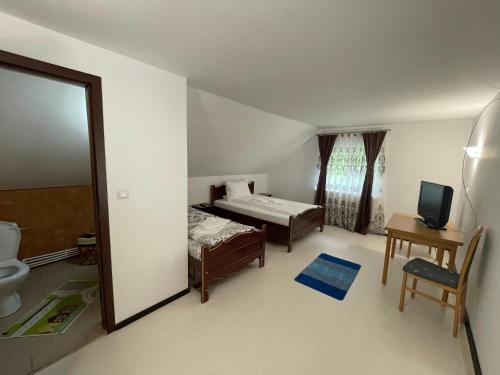 a bedroom with a bed and a bathroom with a mirror at Pensiunea Pe drumuri de munte in Borca