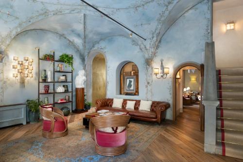 a living room with a couch and a table at The James Suite Hotel Firenze 1564 - Small Luxury Hotels of the World in Florence