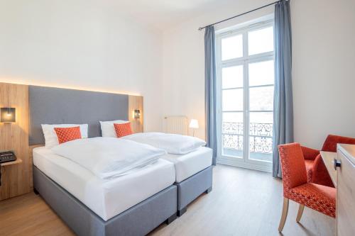 a bedroom with a large bed and a large window at Rheinhotel Schulz in Unkel