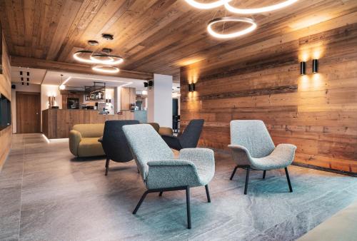 a waiting room with chairs and wooden walls at Oltre Alpine Hotel in Bormio