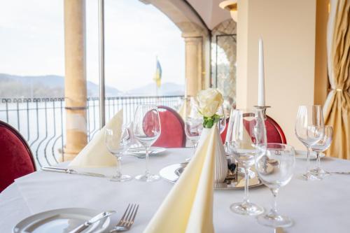 a table with wine glasses and a vase with a flower at Rheinhotel Schulz in Unkel