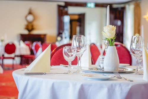 a table with a white flower in a vase on it at Rheinhotel Schulz in Unkel