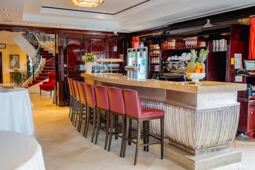 a bar in a restaurant with red stools at Rheinhotel Schulz in Unkel