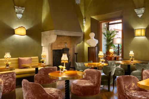 a restaurant with tables and chairs and a fireplace at The James Suite Hotel Firenze 1564 - Small Luxury Hotels of the World in Florence