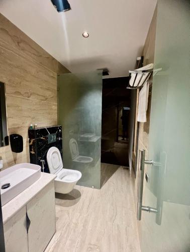 a bathroom with a white toilet and a sink at Hotel Chelsea Plaza in Alīgarh