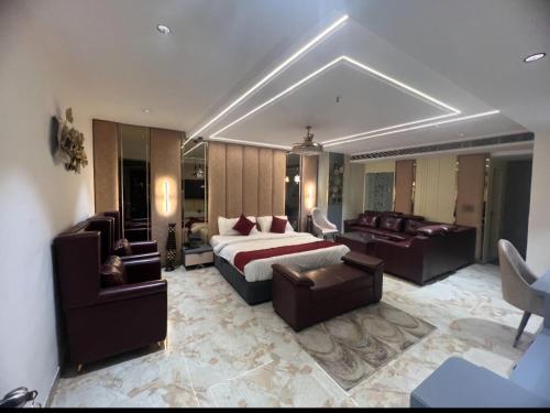 a bedroom with a bed and a living room with a couch at Hotel Chelsea Plaza in Alīgarh