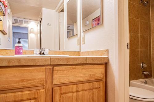 een badkamer met een wastafel, een toilet en een spiegel bij Casa Club Condo in Tucson