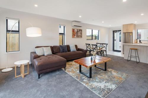 a living room with a couch and a table at Trentham Stylish 2-BR Retreat in Upper Hutt