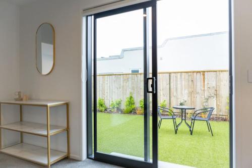 a sliding glass door leading to a patio with a table at Trentham Stylish 2-BR Retreat in Upper Hutt