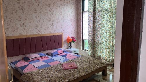 a bedroom with a bed and a window at Lakes and peaks in Srinagar