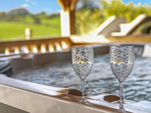 two champagne glasses sitting on a tray with a table at Rose Cottage in Saint Hilary