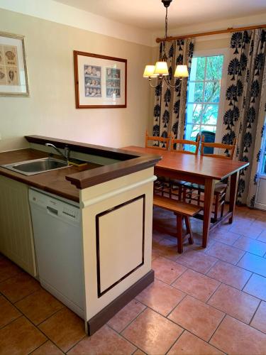 - une cuisine et une salle à manger avec un évier et une table dans l'établissement cottage « maison du golf » à Moliets, à Moliets-et-Maa