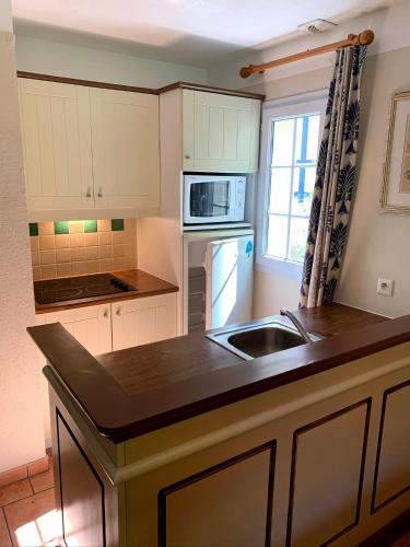 une cuisine avec un évier et un plan de travail dans l'établissement cottage « maison du golf » à Moliets, à Moliets-et-Maa