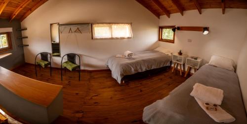 une chambre avec un lit et des chaises dans une pièce dans l'établissement Madre e Hija (refugio de montaña), à El Chalten