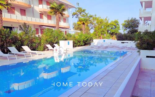 a swimming pool in front of a building at HT - Luxury apartment at Palm Beach Jesolo in Lido di Jesolo