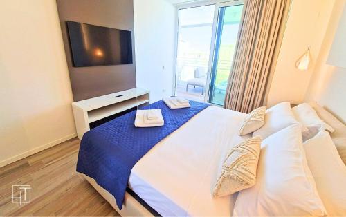 a bedroom with a large bed with a television at HT - Luxury apartment at Palm Beach Jesolo in Lido di Jesolo