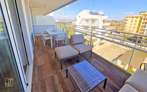 a balcony with a table and chairs on a ship at HT - Luxury apartment at Palm Beach Jesolo in Lido di Jesolo