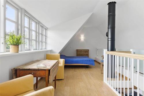 a living room with a blue bed and a table at 6005-Stege-Hjelmvej-15 in Stege