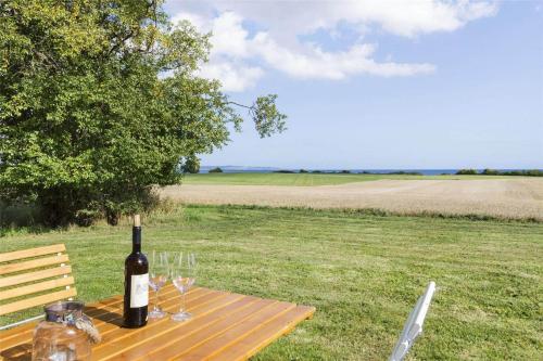 a bottle of wine sitting on a wooden table with wine glasses at 6005-Stege-Hjelmvej-15 in Stege
