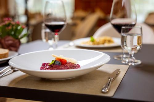 a plate of food on a table with wine glasses at Hotel Posta in Comano Terme